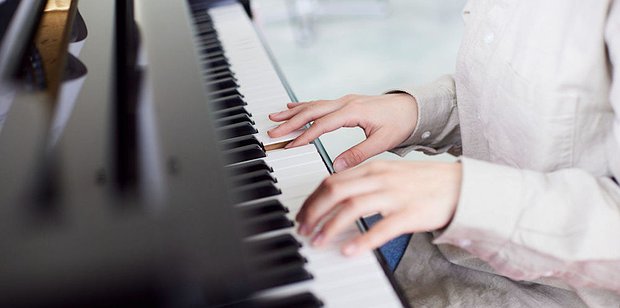 Person playing piano during a music lesson in Toronto