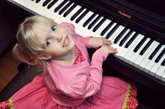 Young child playing piano during a beginner piano lesson in Toronto