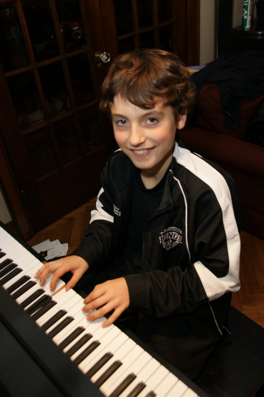 Child playing piano during an in-home piano lesson in Toronto