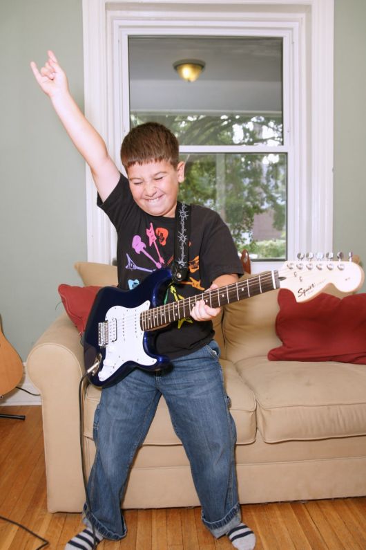 Young boy playing an electric guitar during a guitar lesson for kids in Toronto