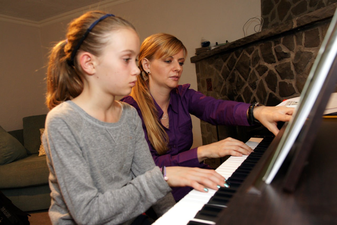 Child learning piano during a private piano lesson with a teacher in Toronto