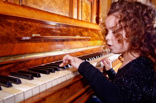 Young student playing piano during a structured piano lesson in Toronto